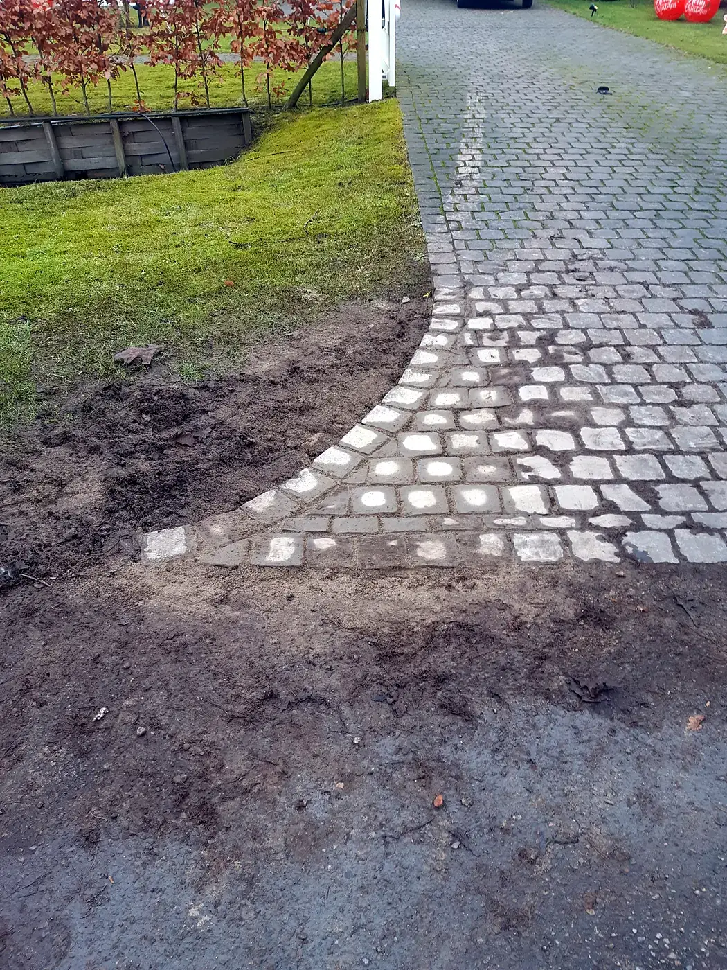 Herstelde kasseien in een boog aan de rand van een oprit